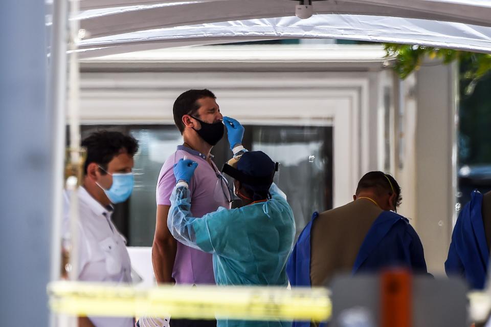 A medical personnel member takes samples on a man at a "walk-in" and "drive-through" coronavirus testing site in Miami Beach, Florida on June 24, 2020. - With coronavirus cases surging across the US South and West, officials are once again imposing tough measures, from stay-at-home advice in worst-hit states to quarantines to protect recovering areas like New York. Nearly four months after the United States reported its first death from COVID-19, the nation faces a deepening health crisis as a wave of infections hits young Americans and experts issue new acute warnings. (Photo by CHANDAN KHANNA / AFP) (Photo by CHANDAN KHANNA/AFP via Getty Images)