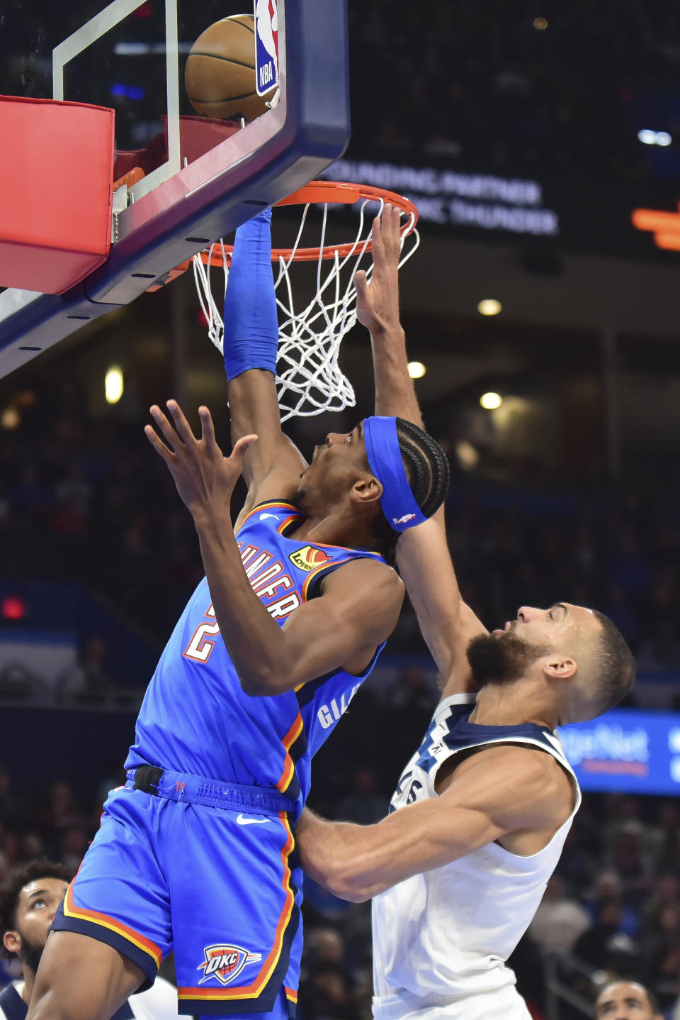 Oklahoma City Thunder guard Shai Gilgeous-Alexander, left, shoots next to Minnesota Timberwolves center Rudy Gobert during the second half of an NBA basketball game Tuesday, Dec. 26, 2023, in Oklahoma City. (AP Photo/Kyle Phillips)