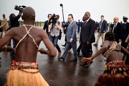 French President Francois Hollande (L) and French Defence minister Jean-Yves Le Drian (R) are welcomed by Central Africa's President Faustin Touadera (C) upon his arrival in Bangui, Central African Republic on May 13, 2016. REUTERS/Stephane De Sakutin/Pool/Files