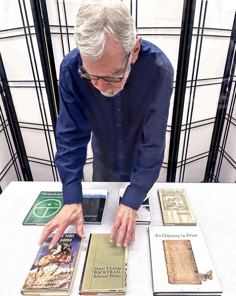 Richard Connolly, Rockland Community College's longest serving tenured professor, arranges books by former colleagues for an exhibit in the Library Media Center at the college.