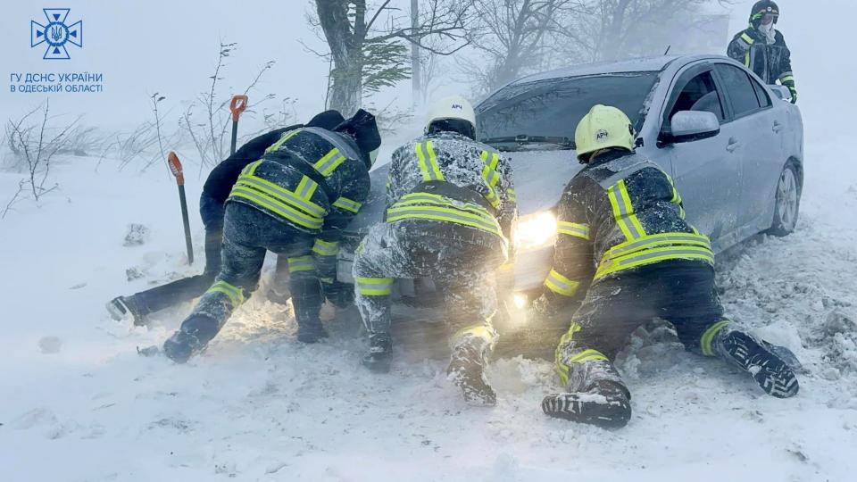 Emergency workers release a car which stuck in snow during a heavy snow storm in Odesa region (via REUTERS)
