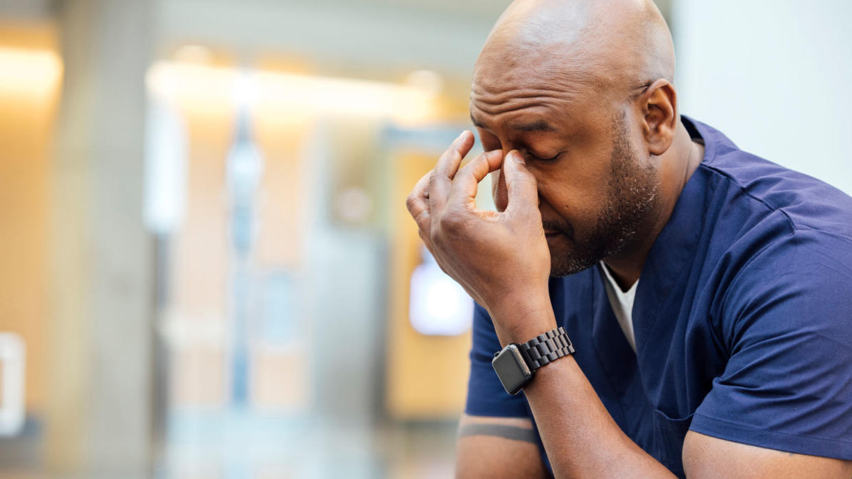  man working in a hospital looking stressed 