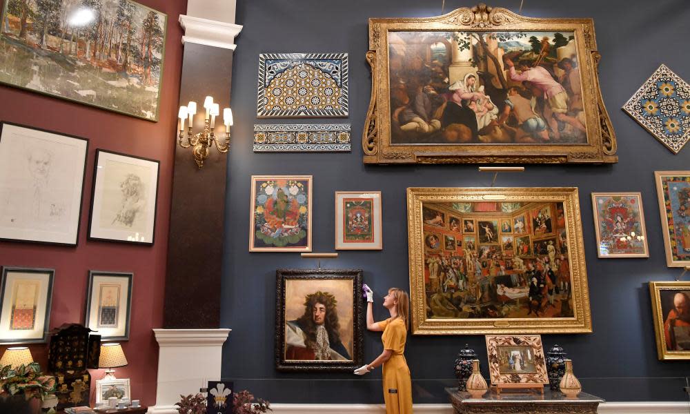 A curator adjusts a painting from the Prince and Patron exhibition at Buckingham Palace.