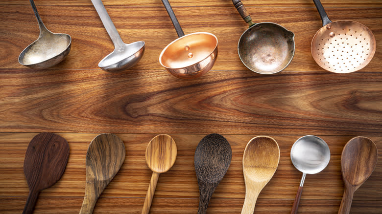 wooden spoons and metal ladles on woo surface