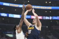Denver Nuggets center Nikola Jokic, right, shoots as Los Angeles Clippers forward Paul George defends during the first half of an NBA basketball game Thursday, April 4, 2024, in Los Angeles. (AP Photo/Mark J. Terrill)