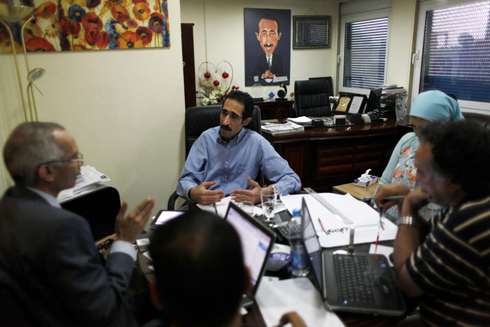 Magdy el-Gallad, center, editor of Al Watan daily newspaper heads an editorial meeting with his team in his office at the newspaper's headquarters in Cairo, Egypt, Wednesday, Sept. 26, 2012. Amid outrage sparked by perceived insults to Islam, one Egyptian newspaper has decided to fight cartoons with cartoons. Al Watan daily says it is responding to the crude caricatures published last week by a satirical Parisian weekly in kind: a series of sketches critiquing relations between the Arab world and the West. The paper says they are a “civilized” alternative to the violent protests across the Muslim world sparked by a low-budget anti-Islam film produced in the United States. (AP Photo/Nasser Nasser)