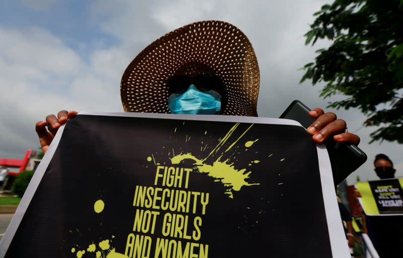 A protester carries a banner during a demonstration to raise awareness about sexual violence, in Abuja