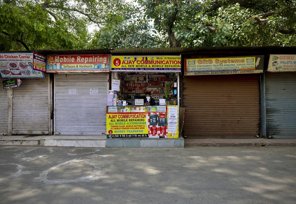 A shopkeeper selling mobile accessories waits for customers during extended lockdown in New Delhi, India, Monday, May 18, 2020. India has recorded its biggest single-day surge in new cases of coronavirus. The surge in infections comes a day after the federal government extended a nationwide lockdown to May 31 but eased some restrictions to restore economic activity and gave states more control in deciding the nature of the lockdown. (AP Photo/Manish Swarup)