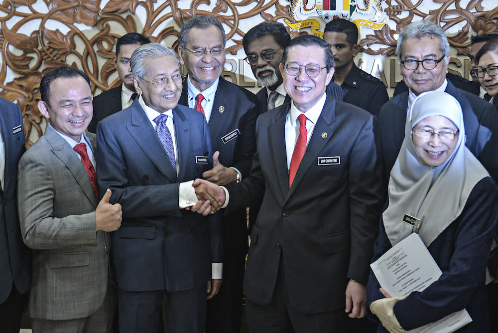 Prime Minister Tun Dr Mahathir Mohamad shakes hands with Finance Minister Lim Guan Eng in Parliament October 11, 2019, after the tabling of Budget 2020. — Picture by Shafwan Zaidon