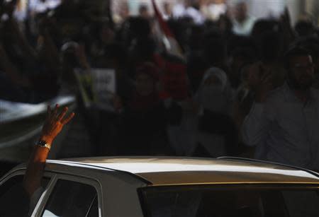 A man in his car shows the "Rabaa" or "four" gesture, in reference to the police clearing of Rabaa al-Adawiya protest camp on August 14, during a traffic jam as members of the Muslim Brotherhood and supporters of ousted Egyptian President Mohamed Mursi stage a protest along a highway in the southern suburb of Maadi September 3, 2013. REUTERS/Amr Abdallah Dalsh