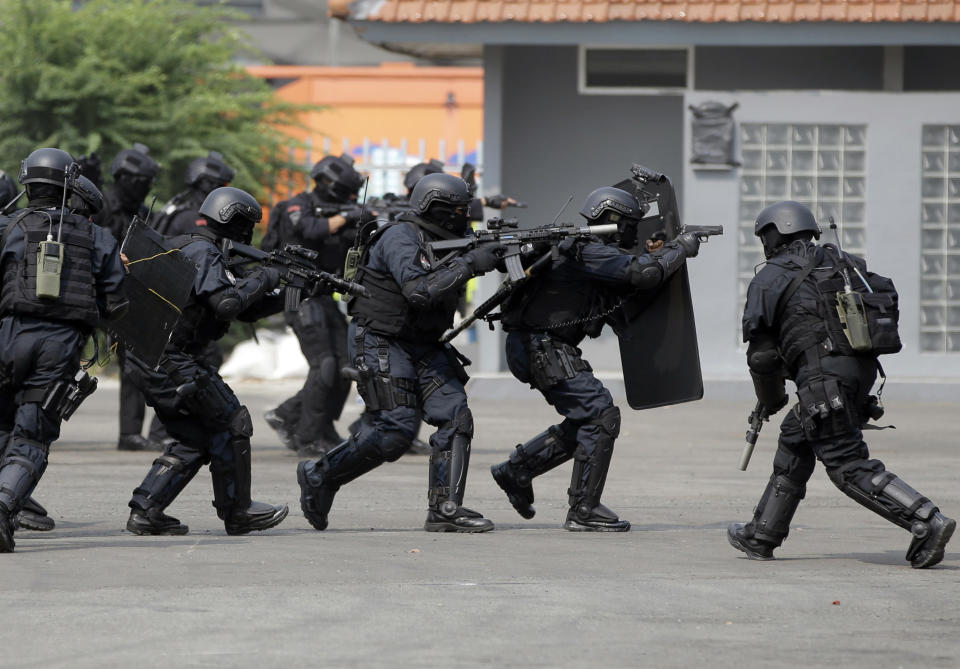 In this July 25, 2018, photo, members of joint Indonesian police and military special forces take part in an anti-terrorism drill ahead of the 2018 Asian Games in Jakarta, Indonesia. Indonesia is deploying 100,000 police and soldiers to provide security for the Asian Games, the biggest event ever held in its terror attack prone capital Jakarta, parts of which have been dramatically spruced up as the city readies to welcome tens of thousands of athletes and visitors. (AP Photo/Tatan Syuflana)