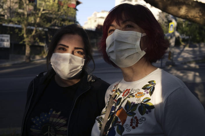 Women wearing masks to help protect against the spread of coronavirus, speak as they walk during a lockdown, in Ankara, Turkey, Tuesday, May 11, 2021. Turkey's daily COVID-19 infections have dropped to levels last seen in mid-March as the country nears two weeks in its strictest restrictions. Heath Ministry statistics showed 14,497 new infections Tuesday and 278 deaths.(AP Photo/Burhan Ozbilici)