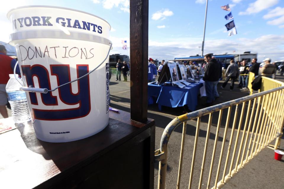 A donation bucket for people suffering from the affects Superstorm Sandy and cystic fibrosis sits on a table near the tailgating area before an NFL football game between the New York Giants and the Pittsburgh Steelers, Sunday, Nov. 4, 2012, in East Rutherford, N.J. (AP Photo/Julio Cortez)