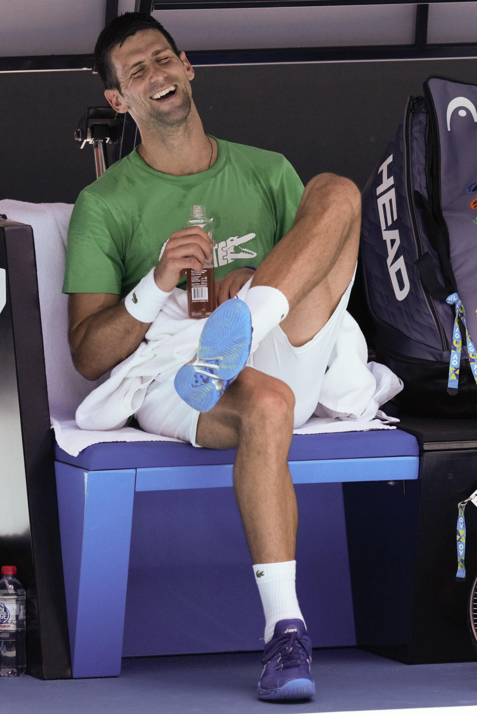 Defending men's champion Serbia's Novak Djokovic laughs as he rests during a practice session on Margaret Court Arena ahead of the Australian Open tennis championship in Melbourne, Australia, Thursday, Jan. 13, 2022. AP Photo/Mark Baker)