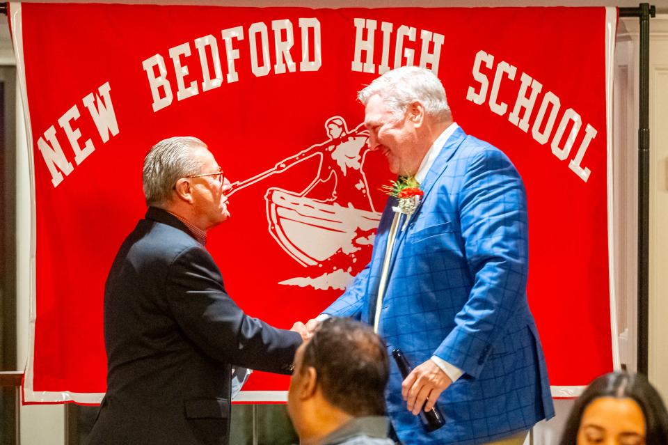 Former New Bedford High School and UMass Dartmouth Ice Hockey Coach, John Rolli, shakes Dean Snell's hand.