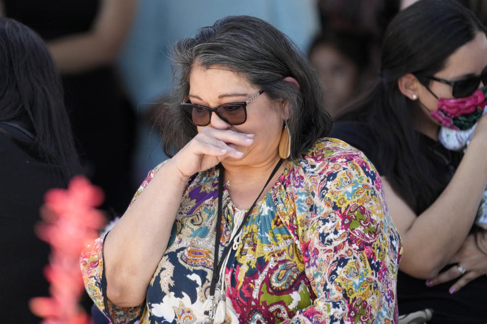 A woman wipes away tears during a vigil for mass shooting victim Daniel Enrique Laso, Sunday, April 30, 2023, in Cleveland, Texas. The search for a Texas man who allegedly shot his neighbors after they asked him to stop firing off rounds in his yard stretched into a second day Sunday, with authorities saying the man could be anywhere by now. The suspect fled after the shooting Friday night that left multiple people dead, including the young boy. (AP Photo/David J. Phillip)