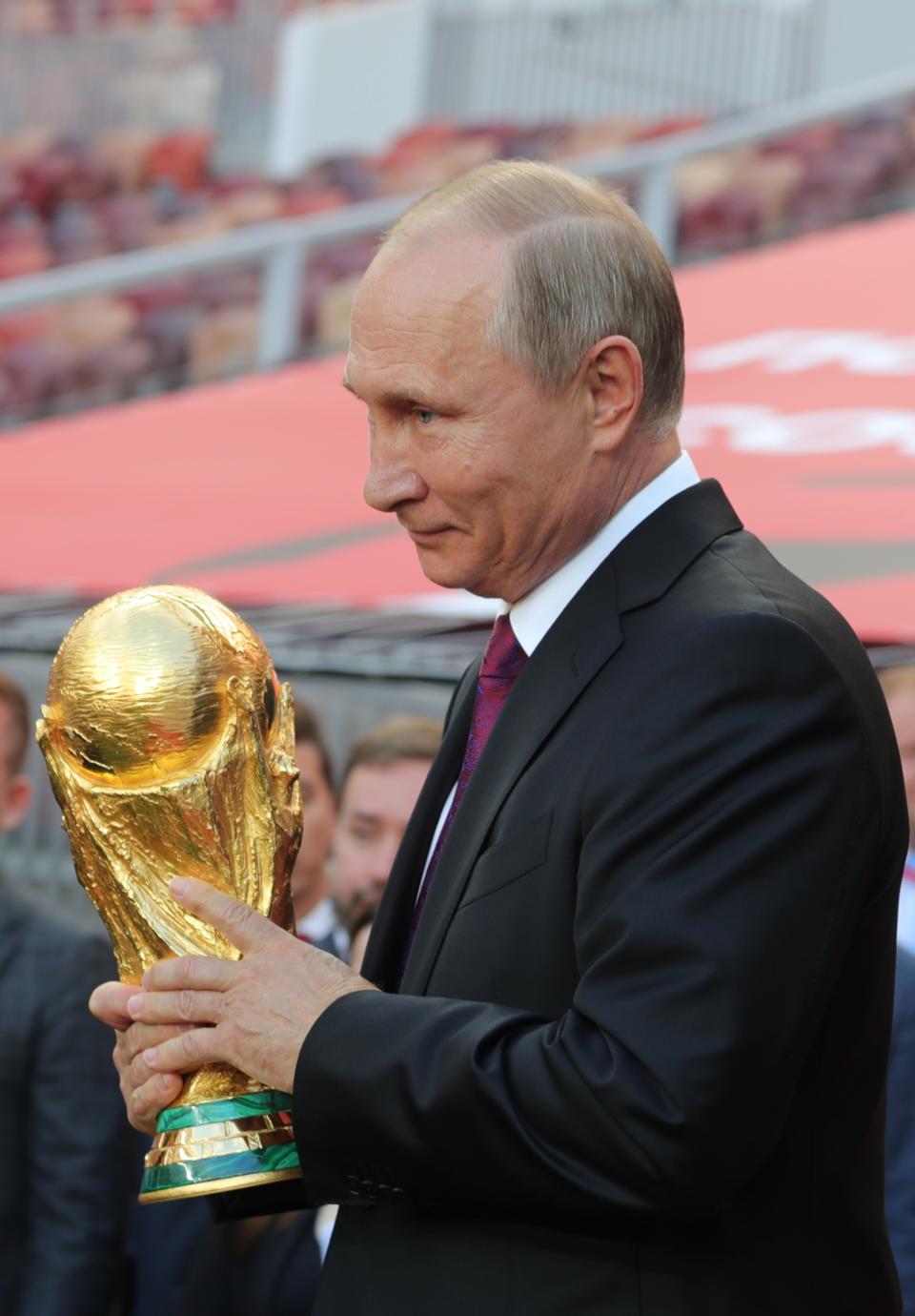 <p>Vladimir Putin with the World Cup trophy (Getty) </p>