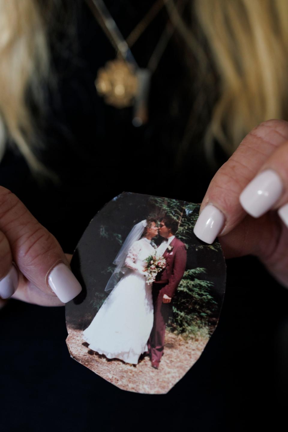 Jocelyn Cronin holds a wedding photo of her and her husband in Petaluma, California. 