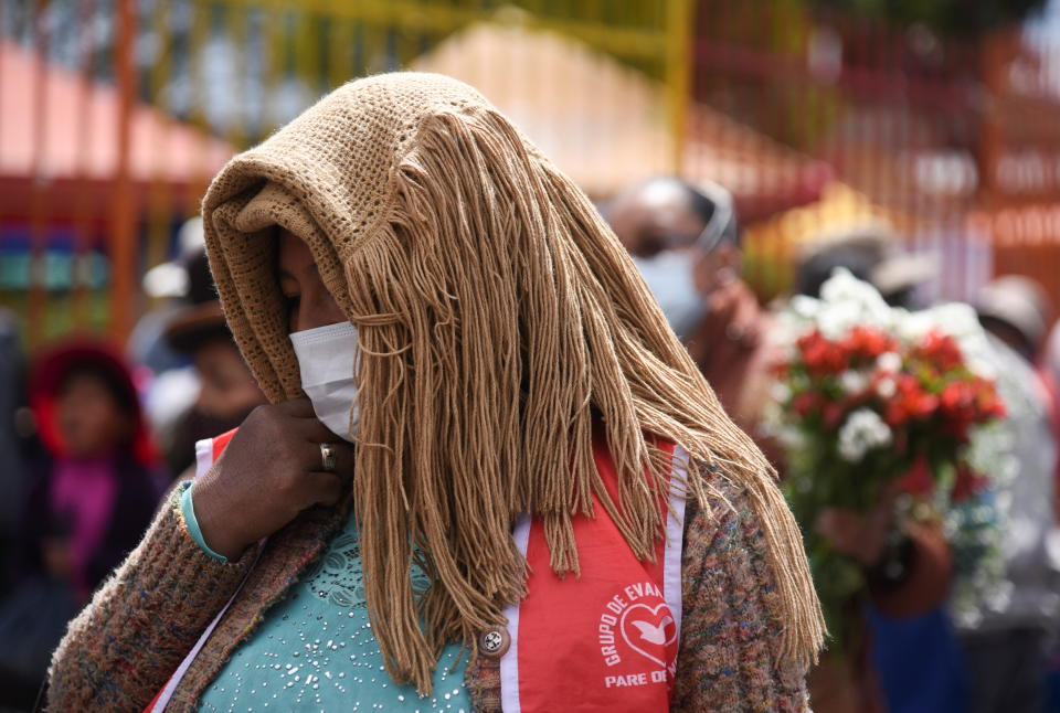 A woman covers her head as she walks on a street under high levels of ultraviolet (UV) radiation amid an unusual heatwave, in La Paz, Bolivia, November 2, 2021. REUTERS/Claudia Morales