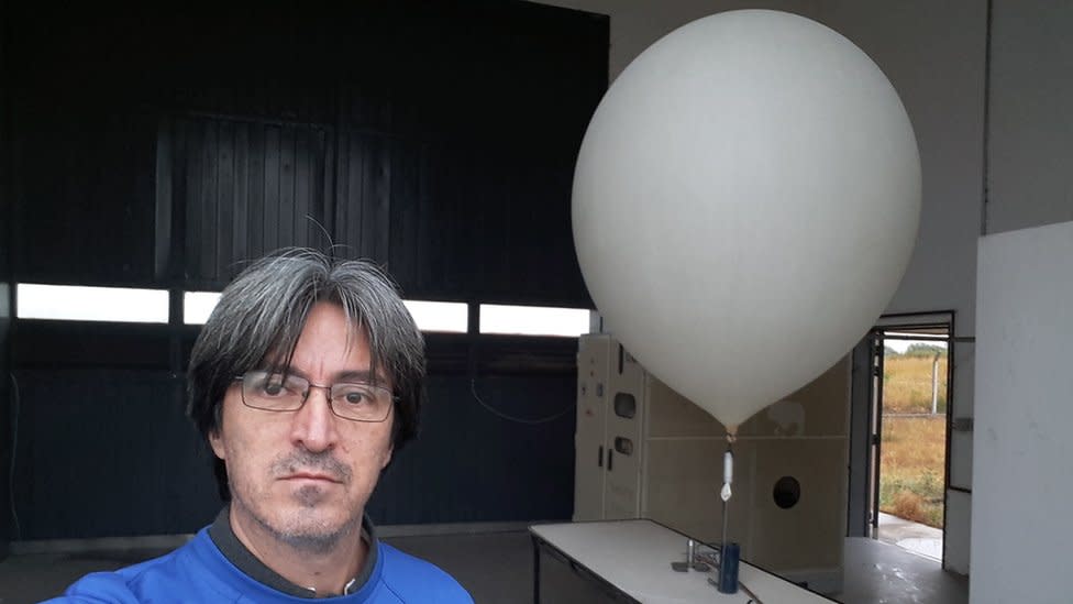 Víctor Oviedo con un globo sonda detrás.