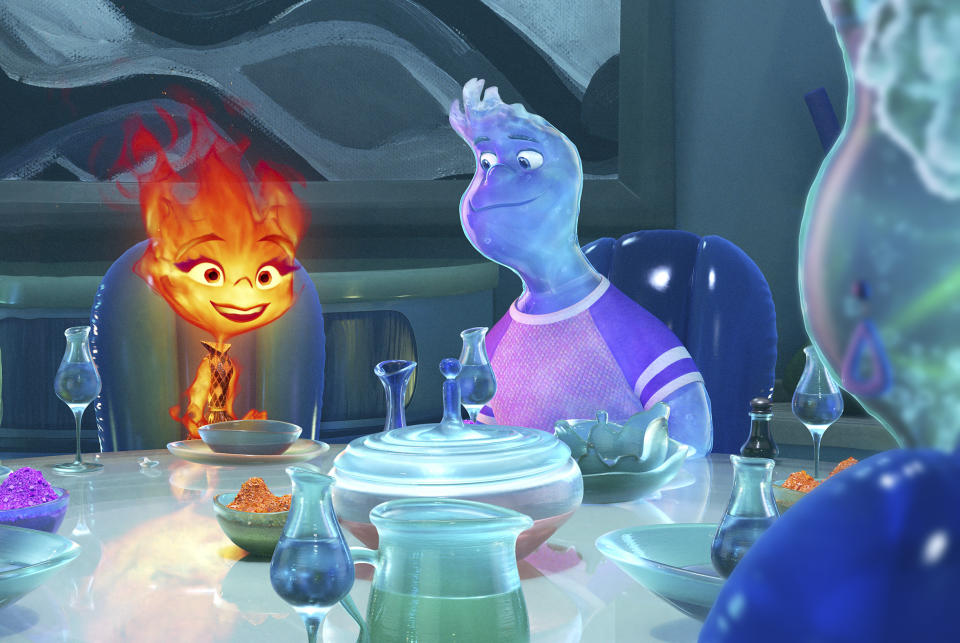 En esta imagen proporcionada por Disney/Pixar Studios, Ember, con la voz de Leah Lewis, izquierda, y Wade, con la voz de Mamoudou Athie en una escena de la película animada "Elemental". (Disney/Pixar vía AP)