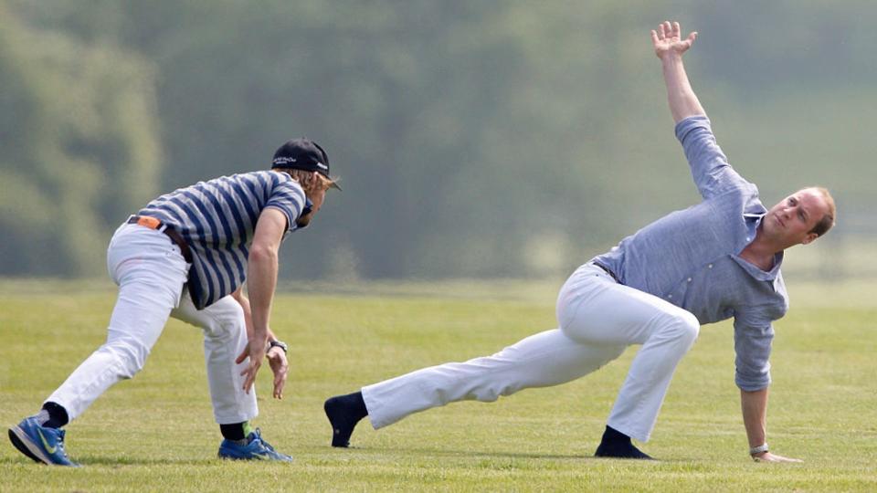 Prince William (r) warms up before talking part in the Audi Polo Challenge at Coworth Park Polo Club