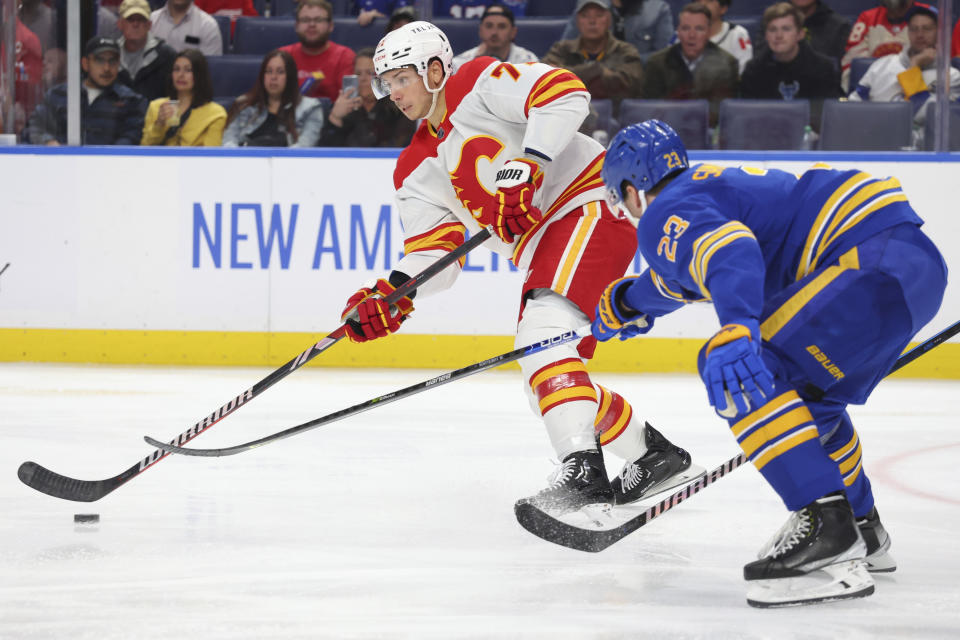 Calgary Flames center Walker Duehr (71) is stick-checked by Buffalo Sabres defenseman Mattias Samuelsson (23) during the second period of an NHL hockey game Thursday, Oct. 19, 2023, in Buffalo, N.Y. (AP Photo/Jeffrey T. Barnes)