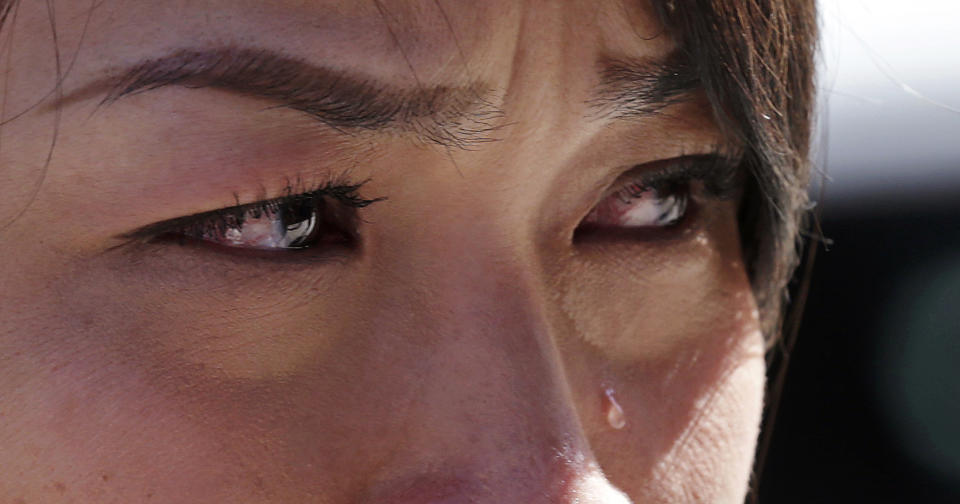 Boston Marathon runner Vu Trang, of San Francisco, cries at a makeshift memorial on Boylston Street near the finish line of the Boston Marathon bombings, which killed three and injured hundreds, April 17, 2013, in Boston. The 10th anniversary of the Boston Marathon bombing on April 17, 2023 will be marked with a wreath laying at the finish line to remember those who were killed, a day of community service and an event for the public to gather to reflect on the tragedy. (AP Photo/Charles Krupa, File)