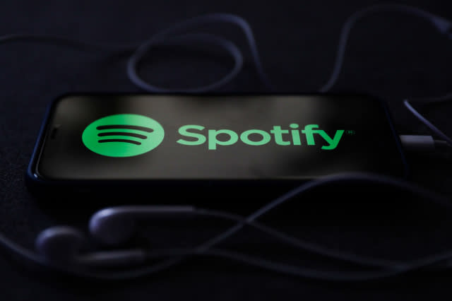 Spotify logo displayed on a phone screen and headphones are seen in this illustration photo taken in Poland on October 18, 2020.   (Photo Illustration by Jakub Porzycki/NurPhoto via Getty Images)