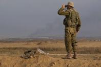 An Israeli soldier looks through binoculars near the border with Gaza July 29, 2014. REUTERS/Siegfried Modola