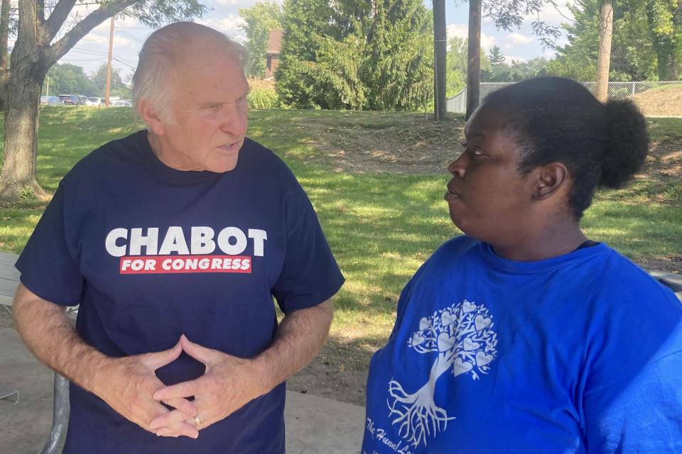 Rep. Steve Chabot, R-Ohio, talks with constituent Latesha Wilson, right, at a park in Reading, Ohio, on Sunday, Sept. 18, 2022. Chabot has tried to tie his Democratic opponent, Cincinnati city council member Greg Landsman, to President Joe Biden, helping illustrate how some Democratic candidates are struggling with how much to embrace -- or distance themselves -- from the president ahead of November’s midterm elections. (AP Photo/Will Weissert)