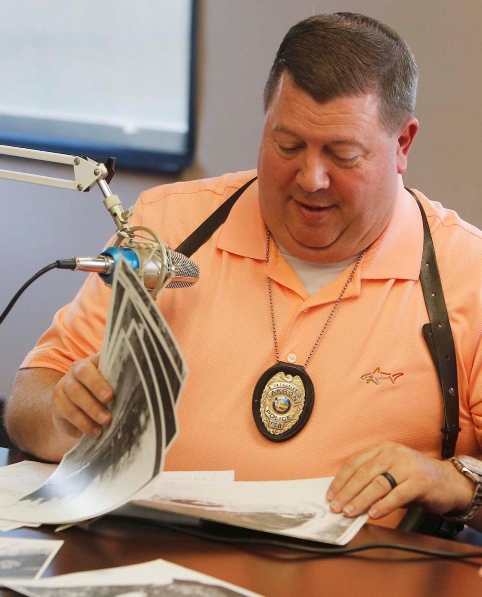 Akron Police Department Detectives James Pasheilich goes through photographs in the case files of murder victim Leslie Barker Wednesday, June 16, 2021 in Akron, Ohio. Barker was murdered in 1978,