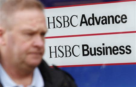 A man passes signage in the window of a branch of the HSBC bank at Hayes in west London February 24, 2014. REUTERS/Luke MacGregor