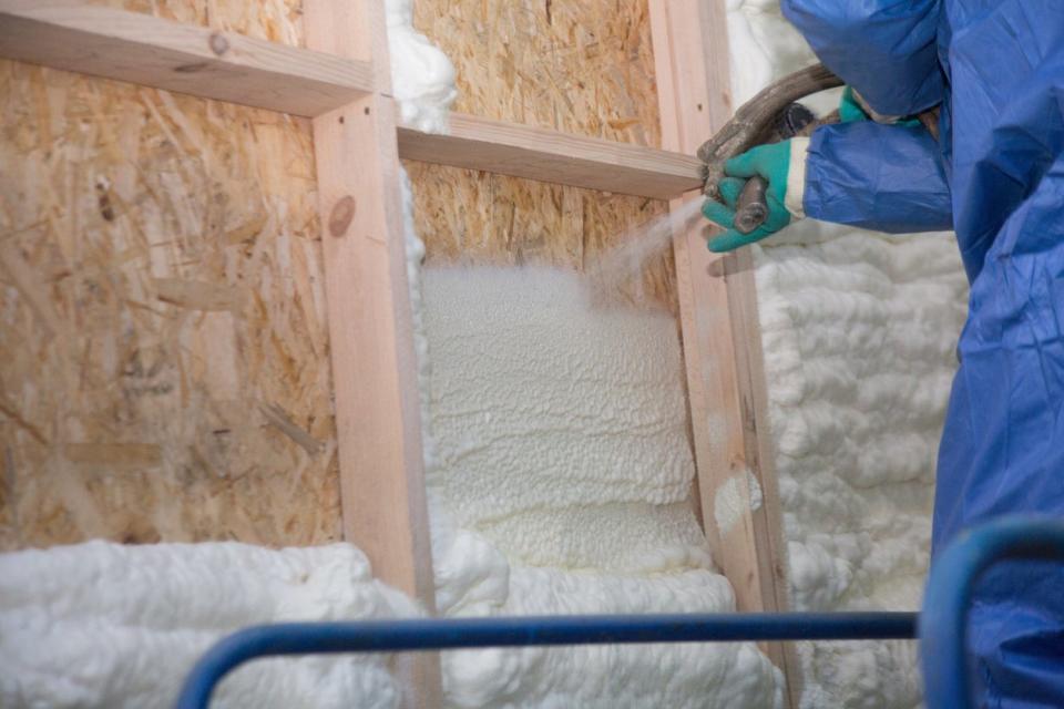 Applying injection foam into wall. 