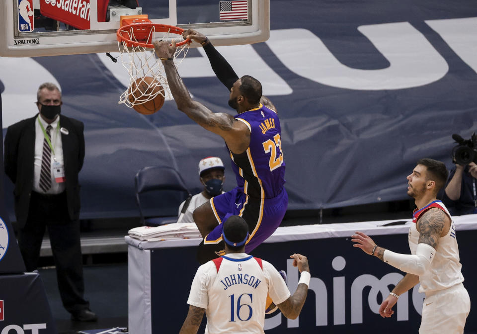 Los Angeles Lakers forward LeBron James (23) dunks over New Orleans Pelicans forward James Johnson (16) and center Willy Hernangomez (9) in the third quarter of an NBA basketball game in New Orleans, Sunday, May 16, 2021. (AP Photo/Derick Hingle)