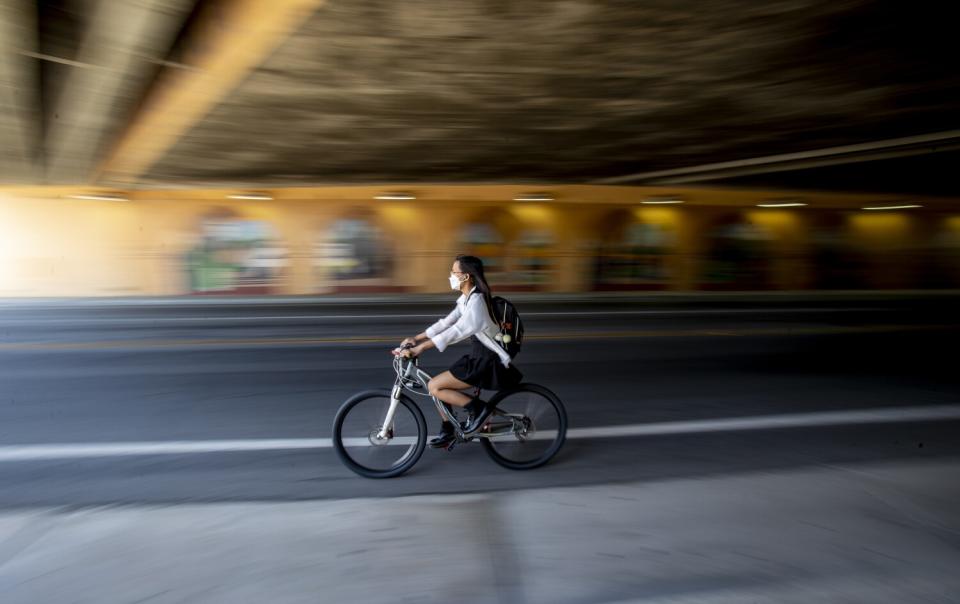 A UC Riverside student rides her bike to get to class at a movie theater about a mile from campus.