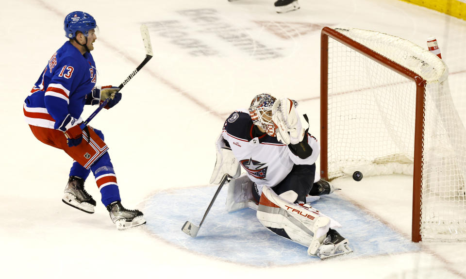 New York Rangers left wing Alexis Lafreniere (13) scores the the winning goal against Columbus Blue Jackets goaltender Elvis Merzlikins, right, during a shootout of an NHL hockey game, Sunday, Nov. 12, 2023, in New York. (AP Photo/Noah K. Murray)