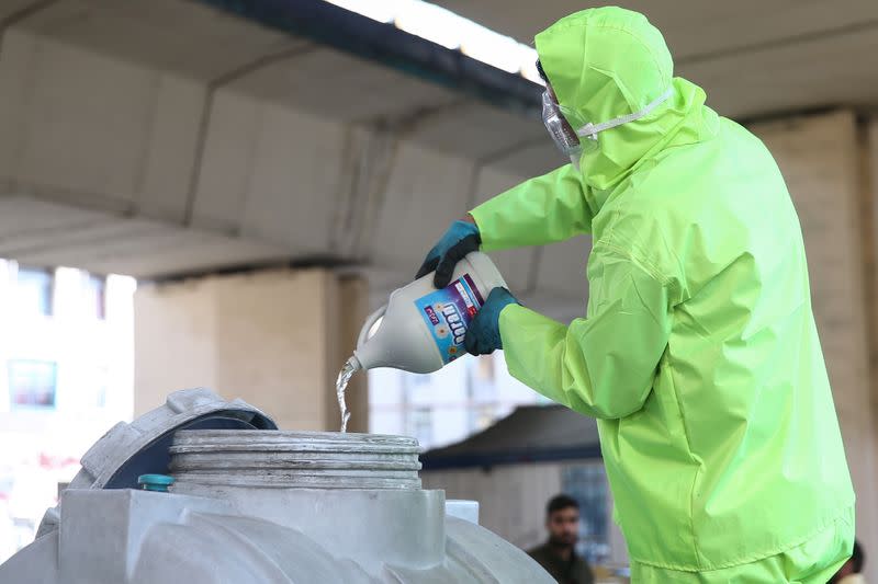 A member of the medical team wears a protective face mask, following the coronavirus outbreak, as he prepares disinfectant liquid to sanitise public places in Tehran