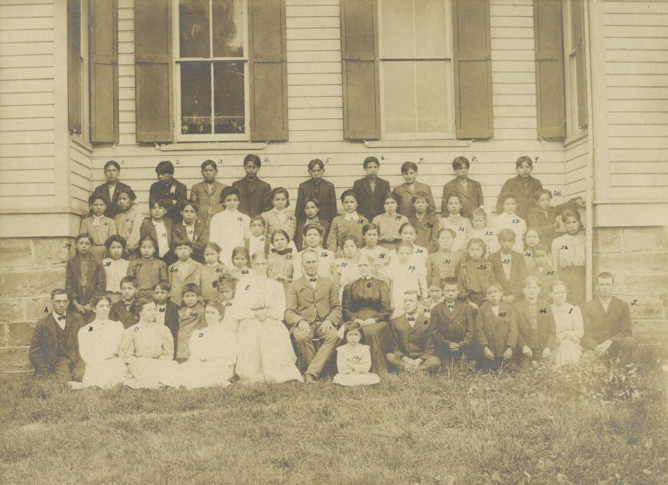 In this photo taken in 1906, provided by the Quaker and Special Collections at Haverford College, teachers and students gather for a portrait at Tunesassa School in Tunesassa, New York. The National Native American Boarding School Healing Coalition says it will digitize 20,000 archival pages related to Quaker-operated Indian boarding schools. The records will provide a better understanding of the conditions that children received at these schools. (Quaker and Special Collections, Haverford College via AP)