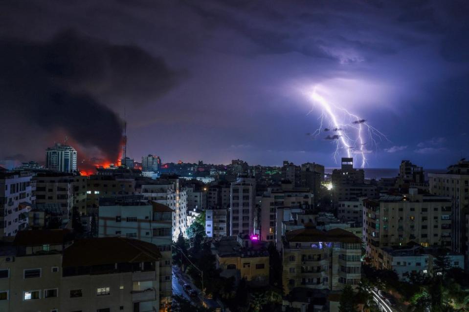 Lightning strikes as smoke billows following an Israeli airstrike in Gaza City on Oct. 9.<span class="copyright">Mohammed Abed—AFP/Getty Images</span>