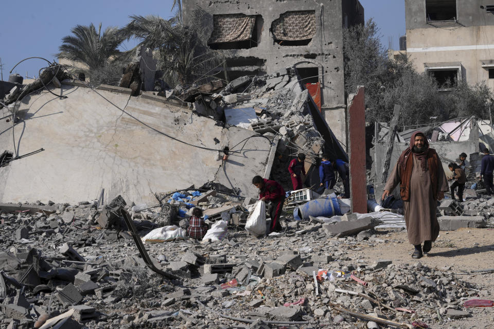 Palestinians salvage belongings from the rubble of a building of the Hamad family destroyed in an Israeli strike in Deir al Balah, Gaza Strip, Friday, Dec. 29, 2023. (AP Photo/Adel Hana)