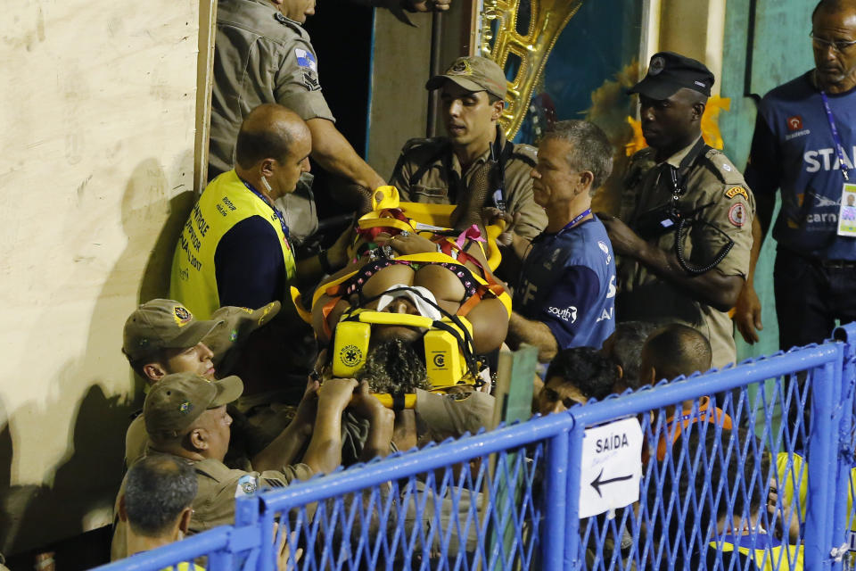 Firefighters carry an injured person on a stretcher to an ambulance during the performing of the Unidos da Tijuca samba school for the Carnival celebrations at the Sambadrome in Rio de Janeiro, Brazil, Tuesday, Feb. 28, 2017. Part of a float has collapsed during Rio de Janeiro's world famous Carnival parade, injuring several people, according to doctors at the scene. (AP Photo/Leo Correa)