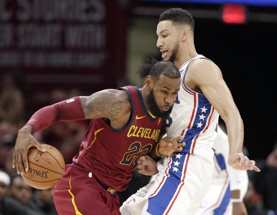 Cleveland Cavaliers’ LeBron James, left, drives past Philadelphia 76ers’ Ben Simmons during the first half of an NBA basketball game, Saturday, Dec. 9, 2017, in Cleveland. (AP Photo/Tony Dejak)