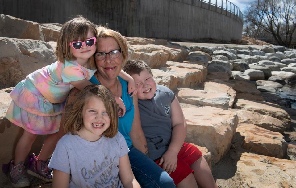 Jeara, a mother of four and a survivor of domestic violence, sits with three of her children for a portrait in Fort Collins. Jeara and her children left her husband on March 5, 2020, the same day that Colorado saw its first reported case of the coronavirus. Now, she and her children live in a domestic violence shelter in the midst of a global pandemic.