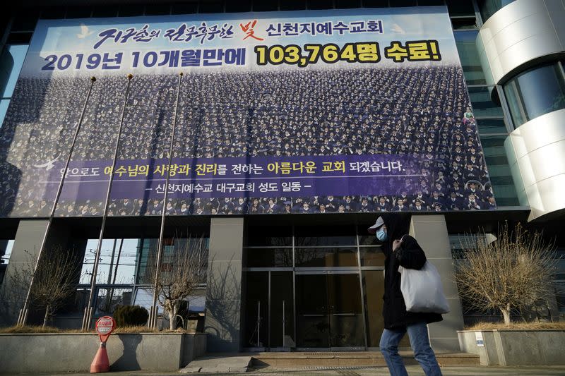 A man wearing a mask to prevent contracting the coronavirus walks past a branch of the Shincheonji Church of Jesus the Temple of the Tabernacle of the Testimony in Daegu