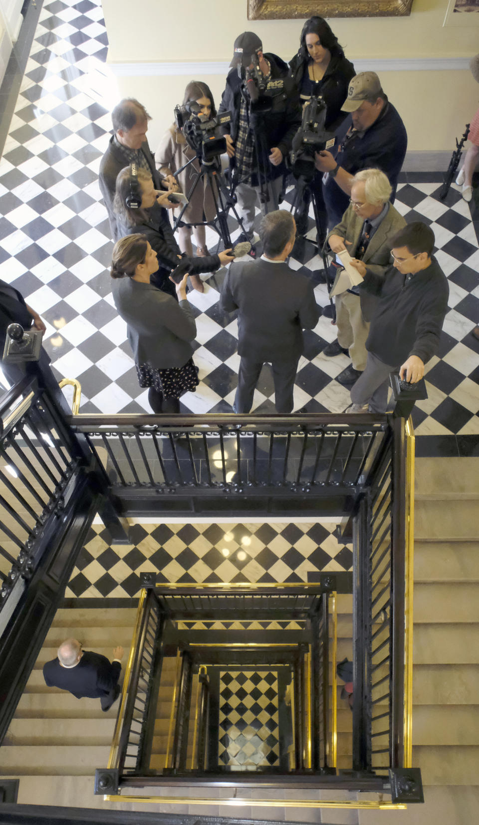 Gov. Ralph Northam , back to camera, talks with members of the media in a hallway after a press conference at the State Capitol Monday, Jan. 6, 2020 where he previewed his voting legislative proposals, including removing Lee-Jackson Day as a state holiday and replacing it with election day. (Bob Brown/Richmond Times-Dispatch via AP)