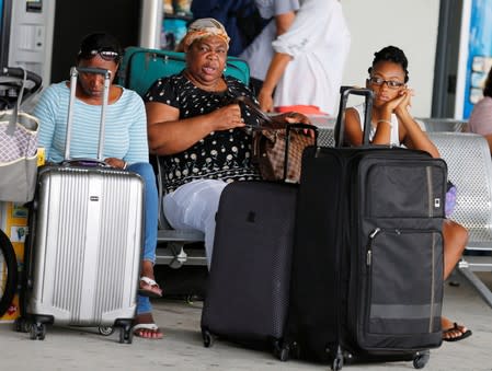 Passengers wait for transportation after disembarking the Bahamas Paradise Cruise Line ship, Grand Celebration, in Riviera Beach