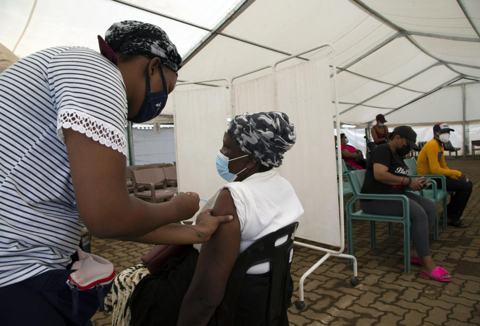 A woman receives a dose of a COVID-19 vaccine at a center, in Soweto, South Africa, Monday, Nov. 29, 2021. The emergence of the new omicron variant and the world’s desperate and likely futile attempts to keep it at bay are reminders of what scientists have warned for months: The coronavirus will thrive as long as vast parts of the world lack vaccines. (AP Photo/Denis Farrell)