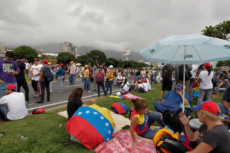 Opposition supporters sit next to the road, as they block a highway during a protest against Venezuelan President Nicolas Maduro's government in Caracas, Venezuela May 15, 2017. REUTERS/Christian Veron