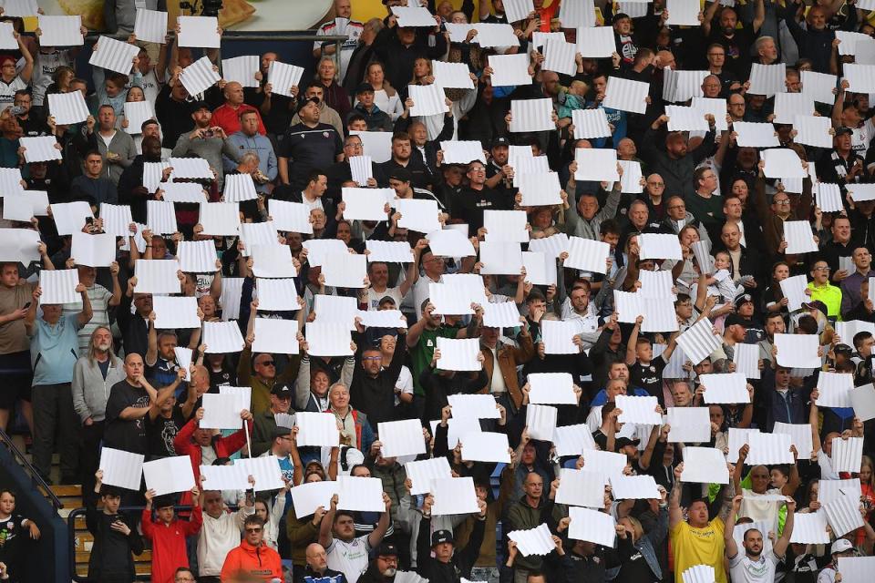Wanderers fans hold up white cards during the second leg of the play-offs in what was a packed out Toughsheet Stadium <i>(Image: Camerasport)</i>